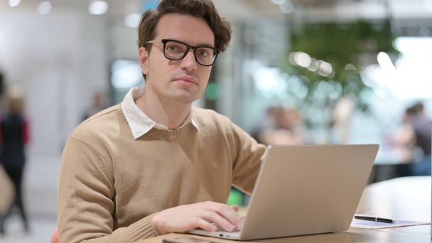 Young Man with Laptop Looking at the Camera  - Photo, Image