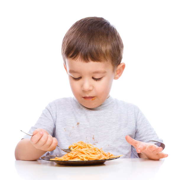 El niño está comiendo espaguetis.
 - Foto, imagen