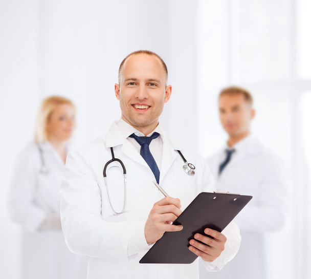 smiling male doctor with clipboard and stethoscope - Foto, Imagen