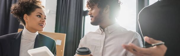 Gente de negocios interracial positiva con tableta digital y café hablando en la oficina, banner  - Foto, imagen