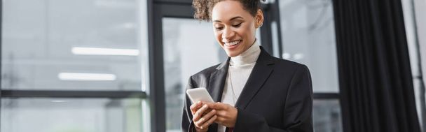 Pozytywna afrykańska bizneswoman używa telefonu komórkowego w biurze, baner  - Zdjęcie, obraz