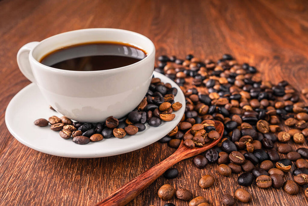 コーヒー カップと木製のテーブルの上のコーヒー豆 - 写真・画像