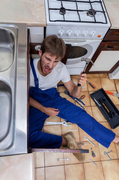 Божевільний чоловік під час ремонту на кухні
 - Фото, зображення
