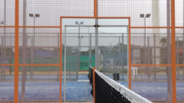 Male padel players handshake after win a padel match in a blue paddel court outdoor. Tennis players shake hands an outdoor courts. - Footage, Video