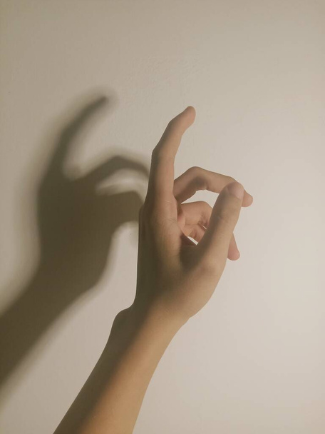 hand holding a white sign on a light background - Fotoğraf, Görsel