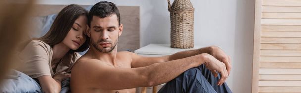 Muscular man sitting near girlfriend with closed eyes in bedroom, banner  - Foto, immagini