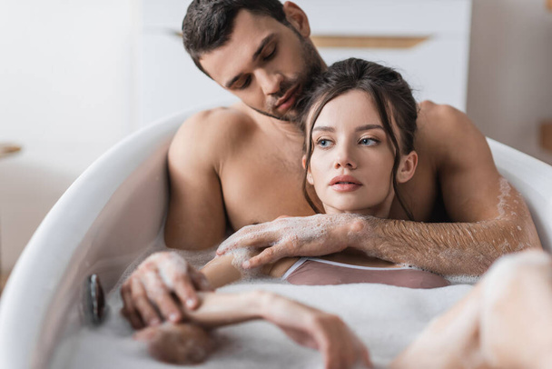 Svalnatý muž objímání přítelkyně při koupeli doma  - Fotografie, Obrázek
