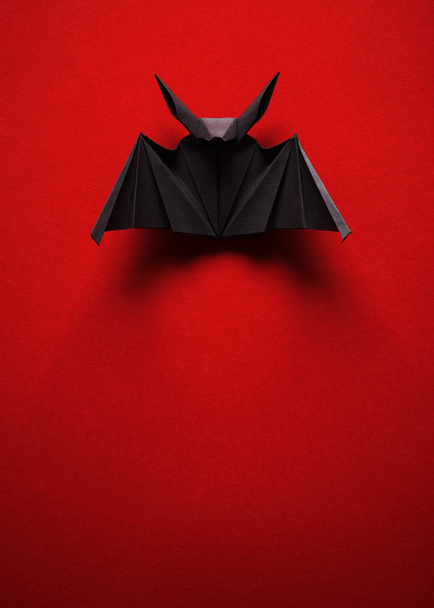 Origami bat on a red background - Фото, изображение