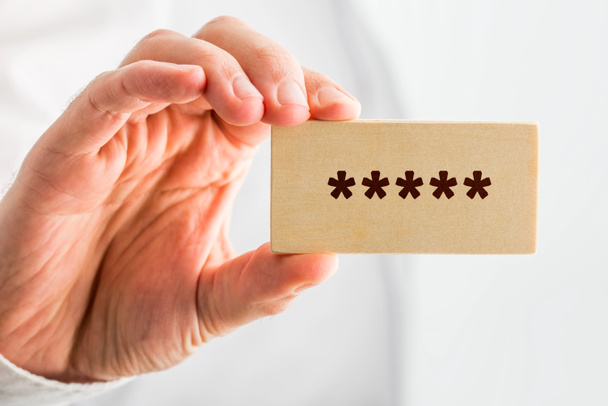 Man holding a wooden block with 5 stars - Photo, Image