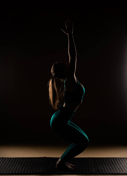 Σιλουέτα ελκυστική και όμορφη κοπέλα κάνει μια άσκηση γιόγκα αναπνοής - Φωτογραφία, εικόνα
