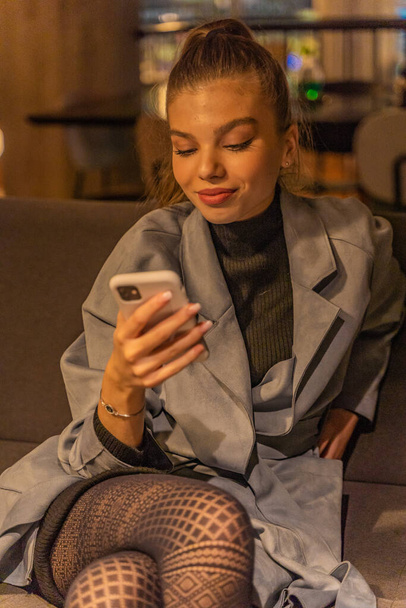 Schöne Mädchen überprüft ihr Handy, während sie mit ihren frineds, asozial - Foto, Bild