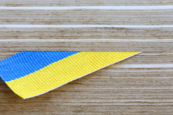 Símbolo nacional de Ucrania. Marcador en forma de bandera de Ucrania entre las páginas de un libro antiguo. Lucha por la libertad y la soberanía. Copiar espacio. - Foto, Imagen