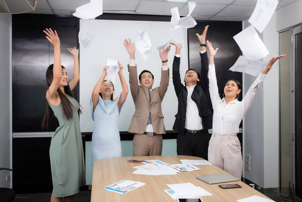 Csoport üzleti csapat boldog dobott dokumentum papírt, miközben találkozott siker kolléga együtt konferenciateremben az irodában, beltéri, közösségi és kommunikációs, csapatmunka dobás papírmunka. - Fotó, kép