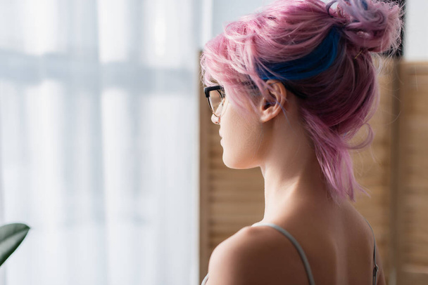 young woman with dyed hair looking away - 写真・画像