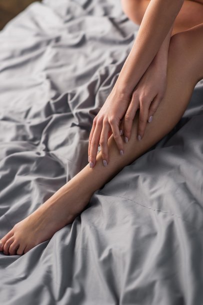 levágott kilátás fiatal érzéki nő megható láb az ágyban - Fotó, kép