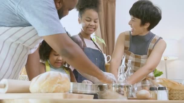 Famiglia afroamericana che indossa grembiule farina trebbia per cucinare panificio o pane insieme in cucina a casa, genitore e bambino preparare il cibo con divertimento e giocoso, rapporto e attività. - Filmati, video