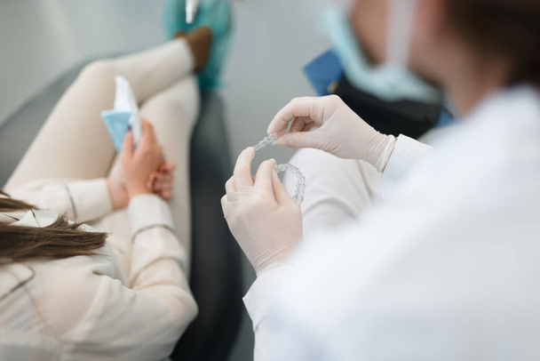 Dentista profissional mostrando e explicando a um cliente como o invisalign funciona - Foto, Imagem