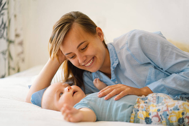 Porträt einer glücklichen Mutter und ihres Kindes. Eine junge Mutter spielt mit einem kleinen Jungen - Foto, Bild
