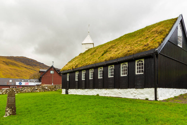Kollafjordur, Faroe Islands, Denmark - 05 May 2018: View of the Kollafjordur Church, Kirkja in small village on Streymoy island. Cloudy day. - Foto, Imagen