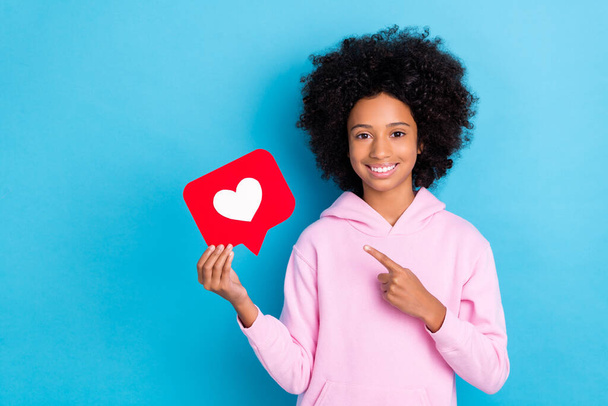 Portrait of attractive trendy cheerful girl holding demonstrating heart card smm post chat isolated over bright blue color background - Фото, изображение