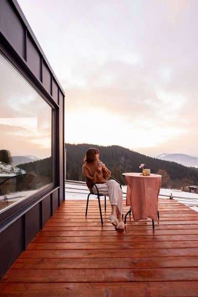 Woman resting at small house in the mountains - Foto, imagen