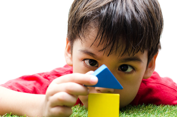 маленький хлопчик будує маленький будинок з різнокольоровими дерев'яними блоками
 - Фото, зображення