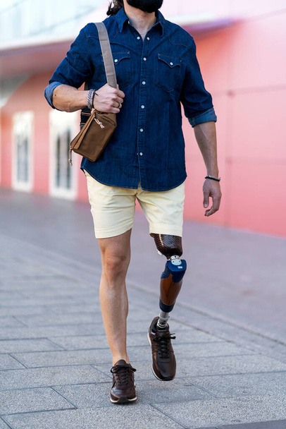 Crop man with artificial limb of leg walking in city - Photo, Image