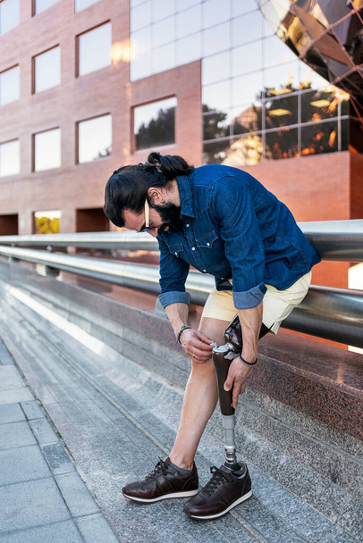 Man met been prothese in de stad straat - Foto, afbeelding