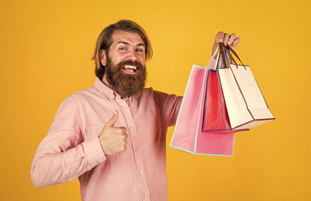 best day ever. mature hipster with beard hold present pack. brutal caucasian hipster with gift. male go shopping with purchase. successful shopaholic. bearded man ready for holiday. sale and discount - Foto, Imagen