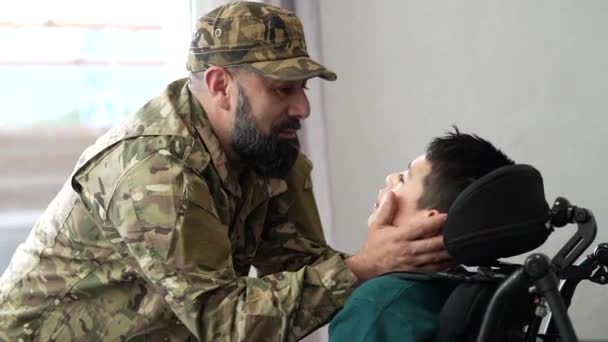 A veterán visszatért a seregből. A felesége és a fia örülnek, hogy láthatják. mozgássérült fiú kerekesszékben - koncepció a háború - - Felvétel, videó