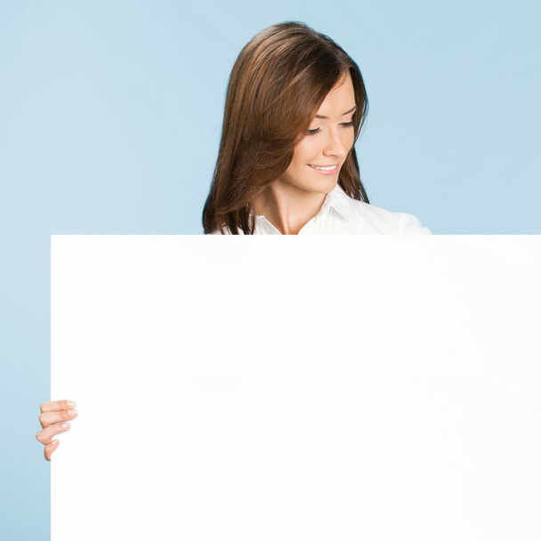 Businesswoman showing signboard, over blue - Foto, Bild