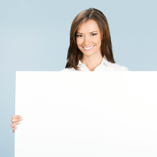 Businesswoman showing signboard, over blue - Foto, Imagen