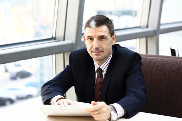 Happy businessman at workplace looking at camera in office - Zdjęcie, obraz
