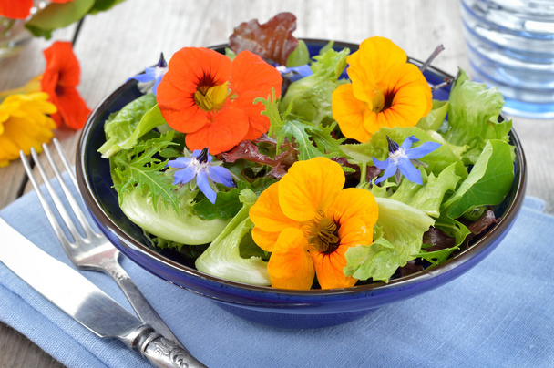 Slaatje met eetbare bloemen nasturtium, Bernagie. - Foto, afbeelding