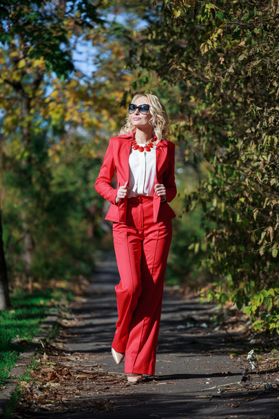 beautiful girl in a red suit in autumn - Фото, изображение