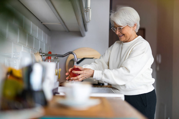 Shot of a senior woman in her kitchen - Foto, Bild
