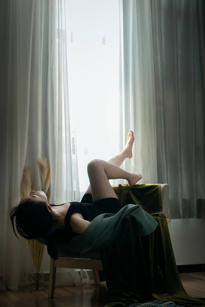 beautiful young woman in white lingerie sitting on the windowsill - 写真・画像