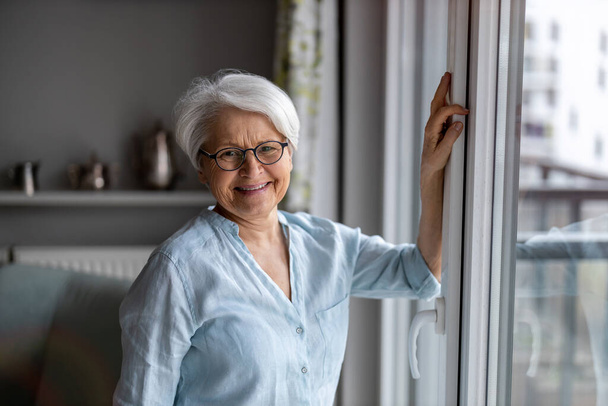 Portrait of smiling senior woman at home - Fotoğraf, Görsel