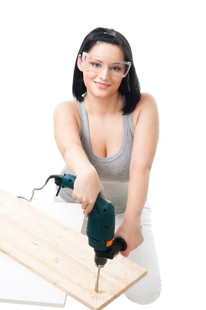 Woman drill hole in wood plank - Zdjęcie, obraz