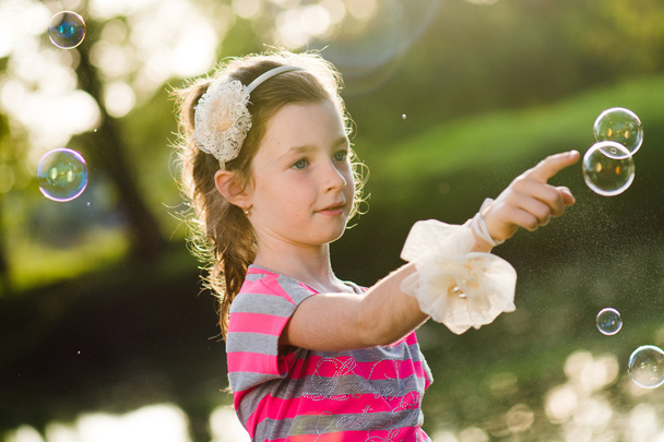 Cute girl chasing soap bubbles - Photo, Image