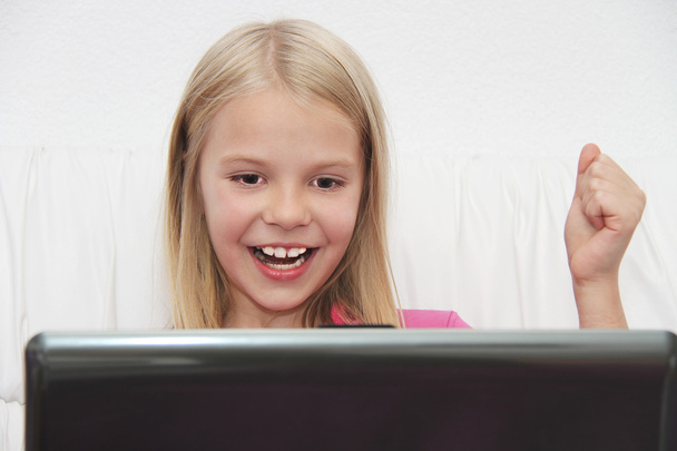 молодая девушка, использующая ноутбук дома - Фото, изображение