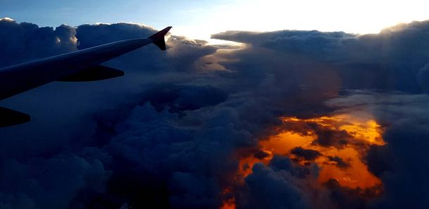 Σιλουέτα του αεροσκάφους ή πτέρυγα αεροπλάνου στο σκοτεινό ουρανό και σύννεφο με φόντο φως ηλιοβασίλεμα με αντίγραφο χώρο. Μεταφορά, Ταξίδια και Ομορφιά της Φύσης ή Φυσικό.  - Φωτογραφία, εικόνα
