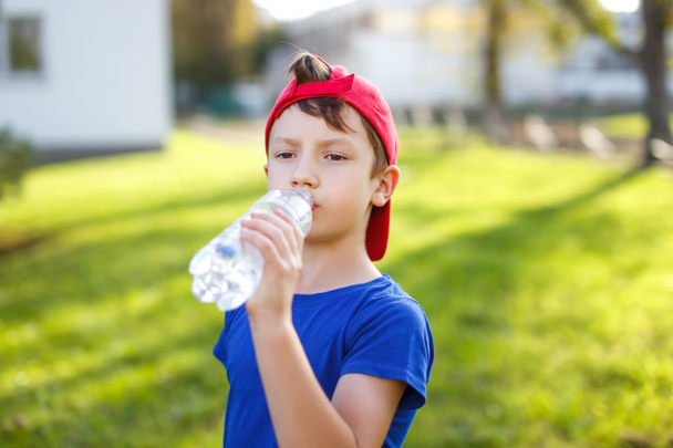 Pieni poika juo vettä pullosta
 - Valokuva, kuva