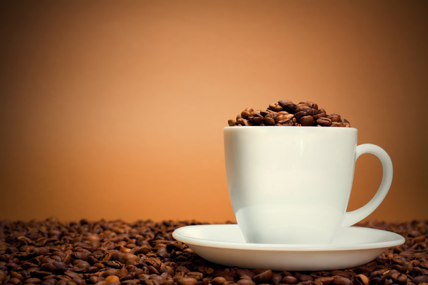 White cup filled with coffee beans - Photo, Image