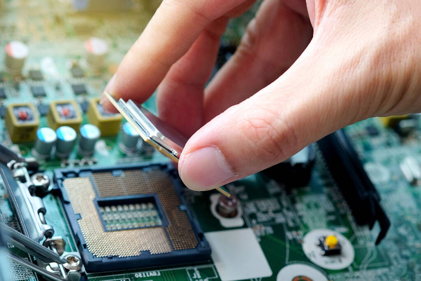 Hand of computer engineering brings computer cpu processor memory change components into socket processor for maintenance.Technology and development concept - 写真・画像