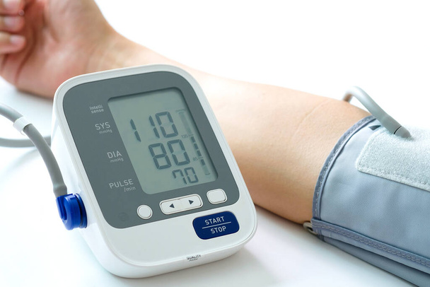 血圧計で血圧モニターと心拍数モニターをチェックしてる。ヘルスケアと医療の概念 - 写真・画像