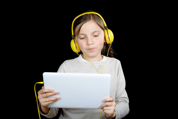 a beautiful young girl listening to music with a digital tablet - Фото, зображення
