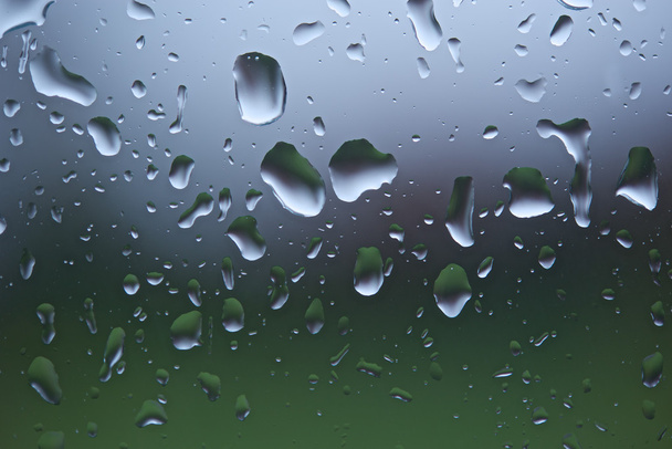Des gouttes de pluie sur une fenêtre et un fond déconcentré
 - Photo, image