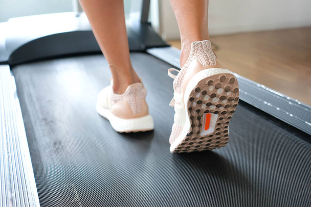 leg of woman running on treadmill in the gym which runner athletic by running shoes. Health and sport concept background, - Foto, Imagem