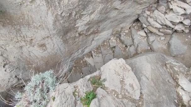 イタリア、カンパニア州マサ・ルブレンス2022年3月20日:プンタ・カンパネラの崖の間のミネルバ洞窟へのアクセス階段の概要 - 映像、動画